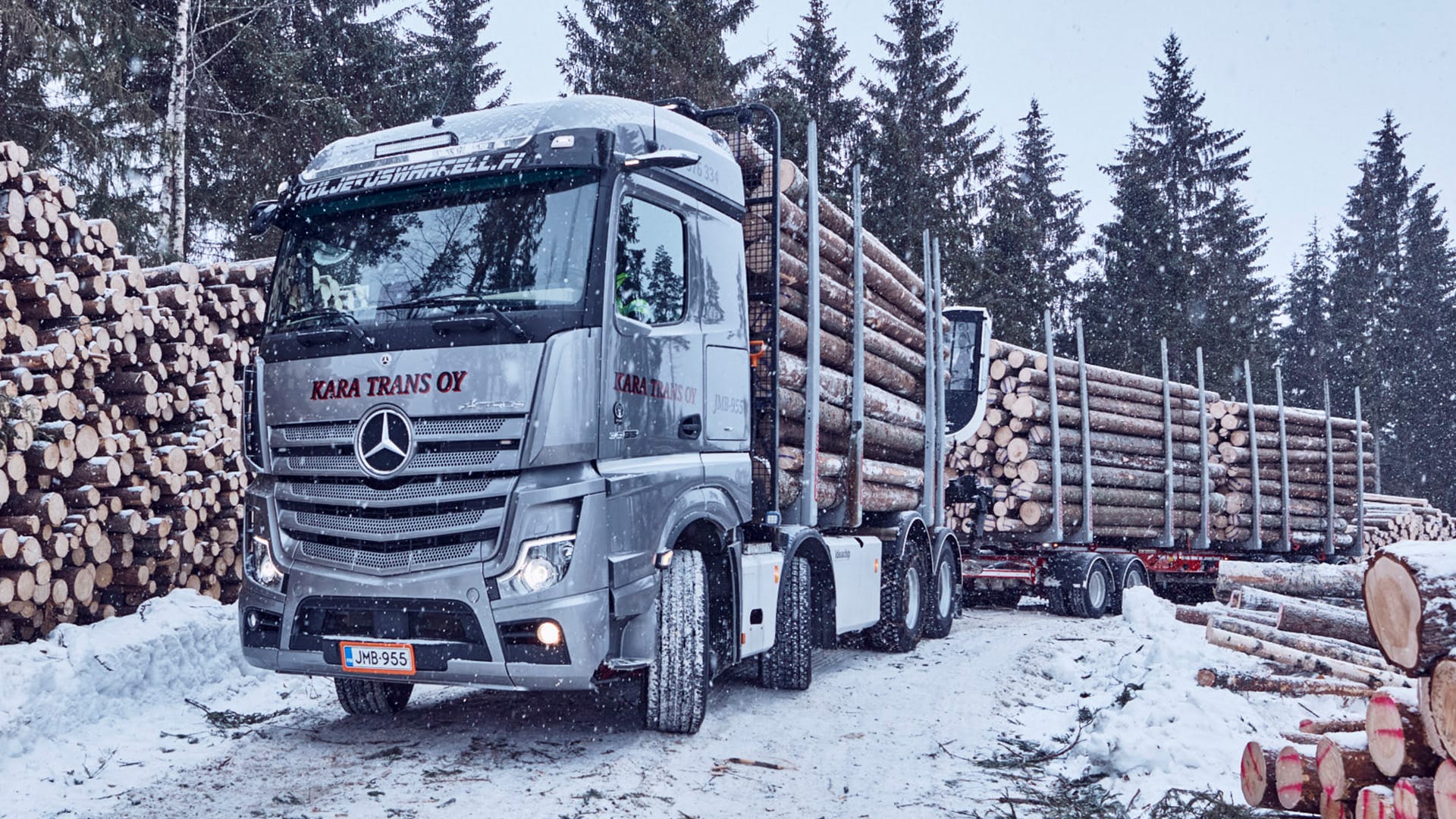 Kara Transin Arocs -puuauto puukuorman edessä