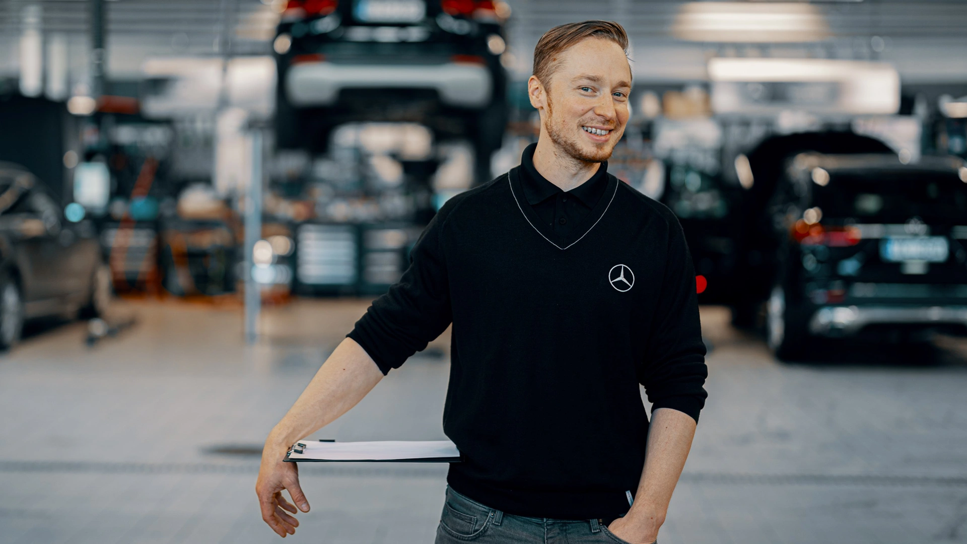 Young man standing in Veho's vehicle service hall in Vantaa.