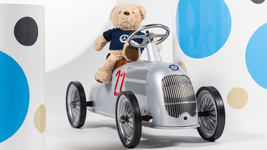 Lelunalle istumassa Mercedes-potkuauton päällä.