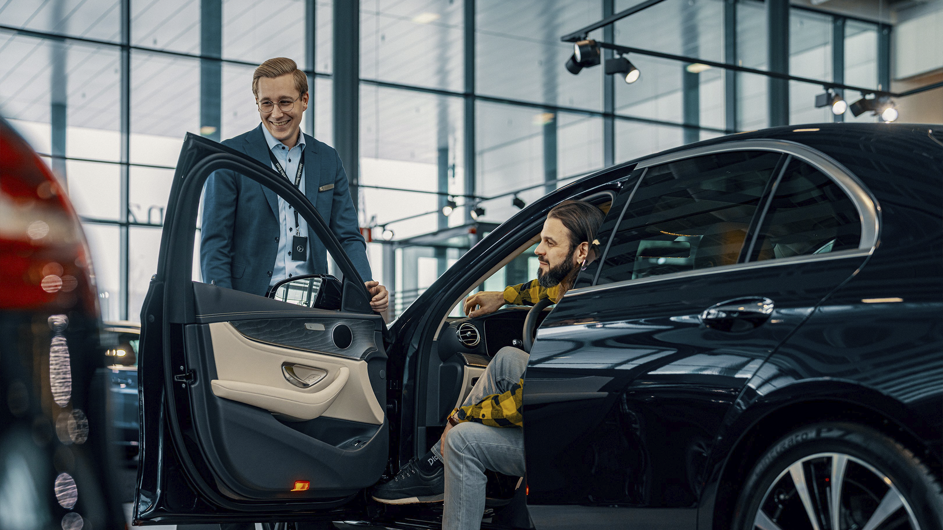 Automyyjä ja asiakas keskustelevat autosta