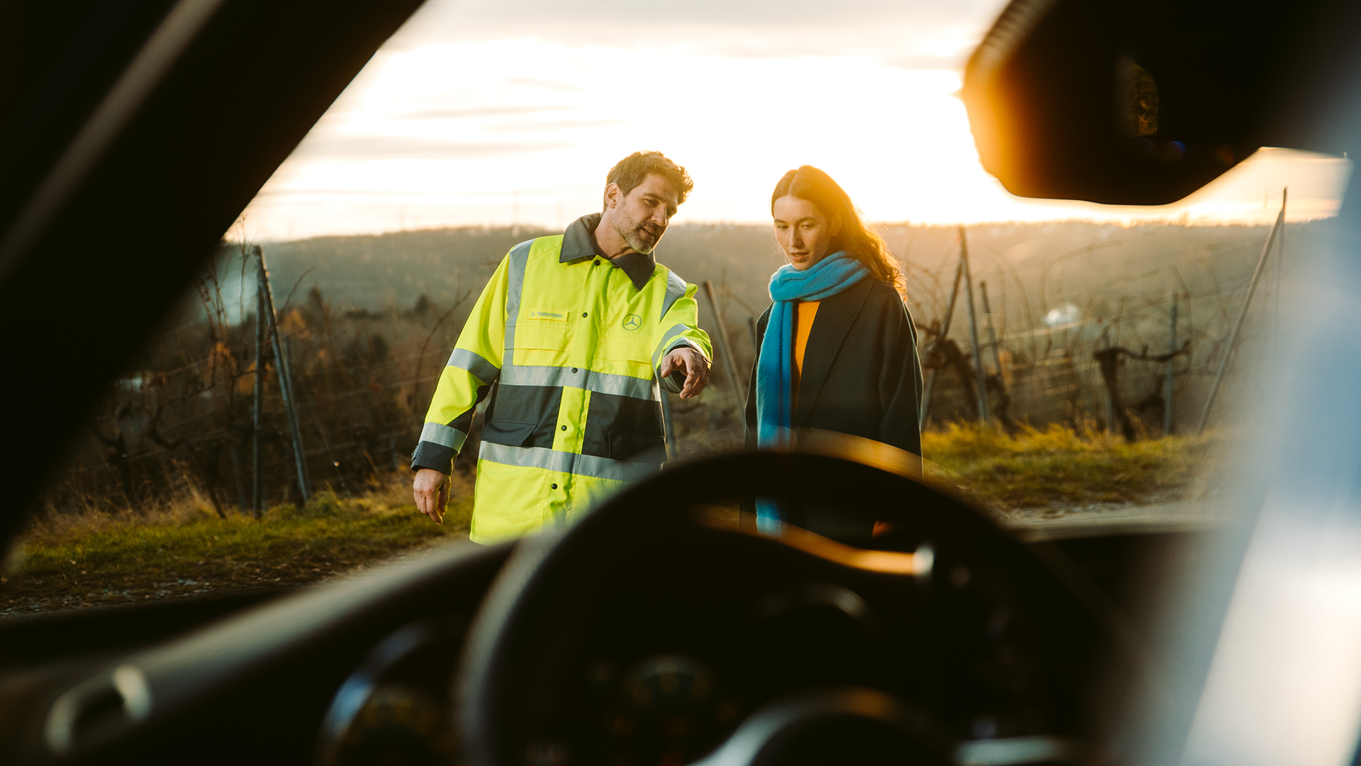 Mercedes-tiepalvelumekaanikko keskustelemassa asiakkaan kanssa auton ulkopuolella.