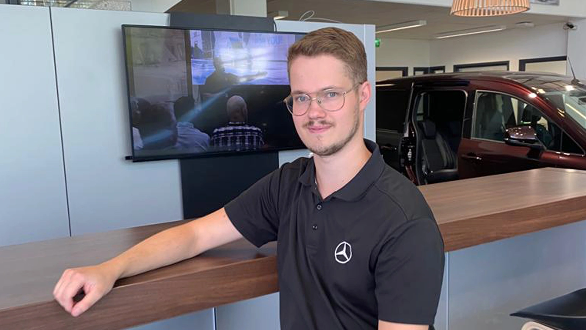 Nuori mies autoliikkeessä kesätöissä.