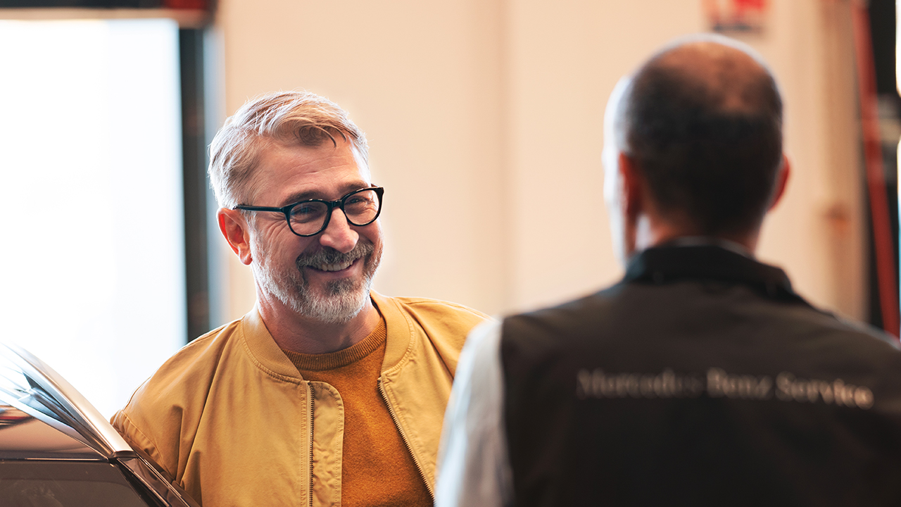 Asiakas ja asiakaspalvelija keskustelemassa.