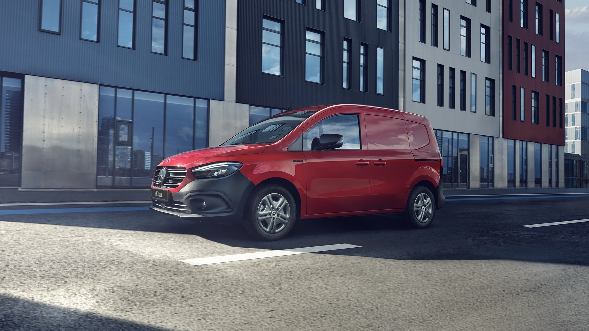 Mercedes-Benz eCitan ajaa kerrostalojen edessä.