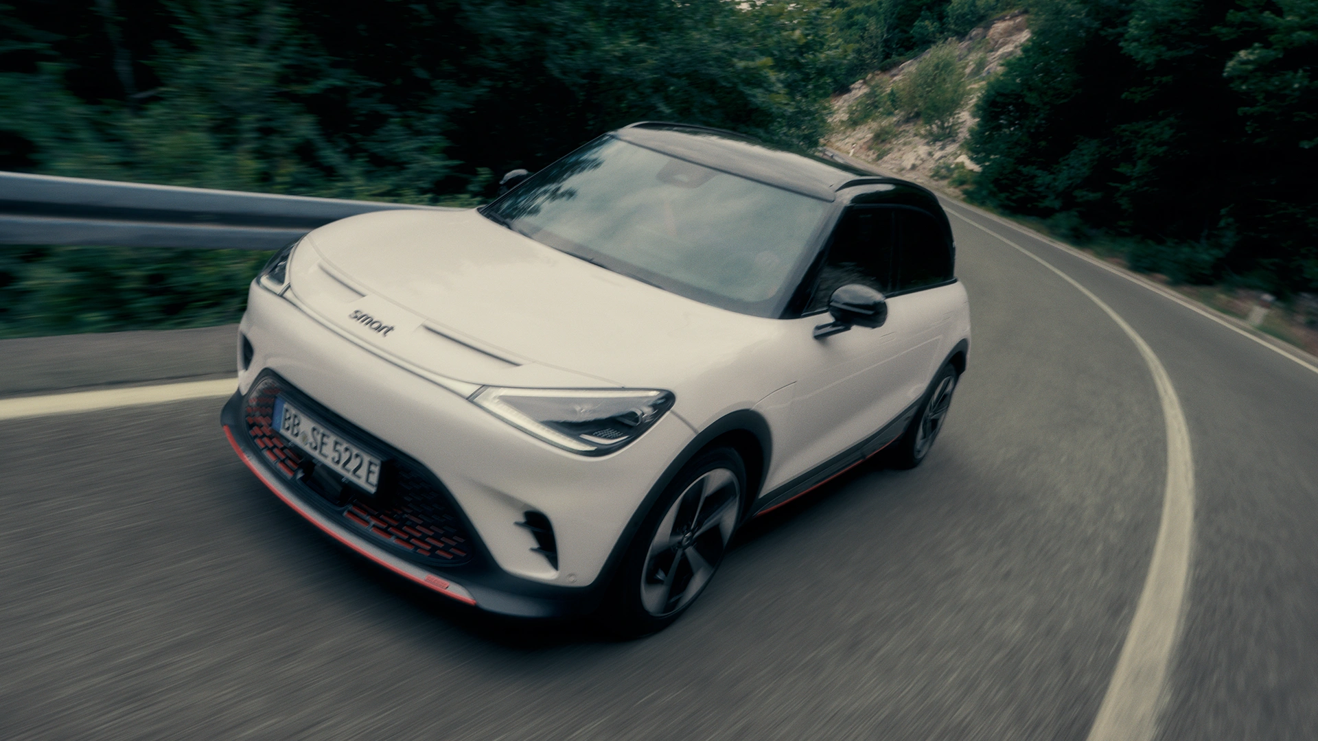 Valkoinen smart #1 henkilöautot ajaa maantiellä.